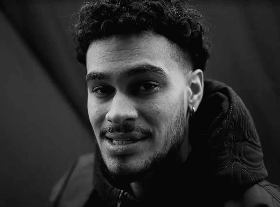 Still from the Faith video: Osk in black and white, close-up, smiling.